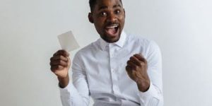 Young man with betting slip looking happy