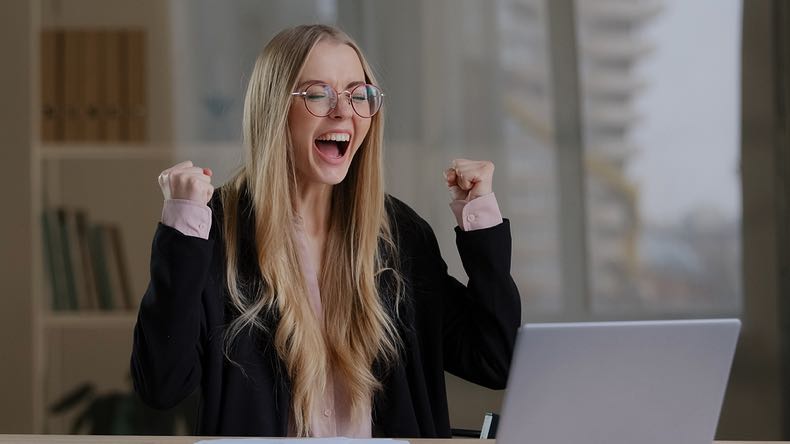 Woman excited at laptop